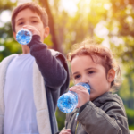 2 childs drinking bottled water