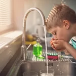 child drinkig tap water