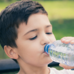 child drinking bottle of water