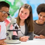 little scientists with microscope in lab