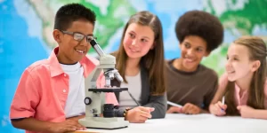little scientists with microscope in lab