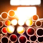 many copper pipes with sun