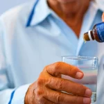 scientist with a glass of water with chemicals