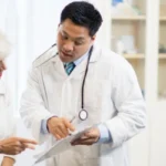 asian male doctor with old patient