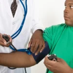 black doctor checking black patient