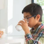 boy with shirt drinking water