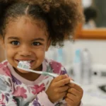 cute black girl brushing teeth