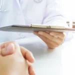 doctor holding a tablet speaking with patient