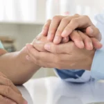 doctor holding hand of old woman