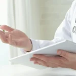 doctor with stethoscope on shoulders and tablet