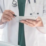 doctor with stethoscope showing results on tablet