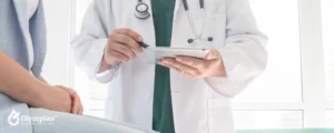 doctor with stethoscope showing results on tablet