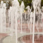 girl playing in public water fountain
