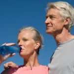 old couple drink water from plastic bottle