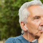 old man listening to music and drinking water