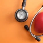 stethoscope and hearth orange background