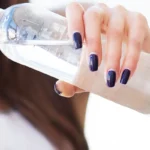 woman pouring water from plastic bottle