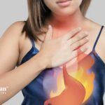 Woman with heartburn. Alkaline water may improve digestion and reduce acid reflux.