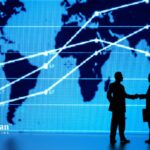 Alkaline water market trends. Business people shake hands in front of a world map with market growth lines.