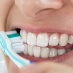 Brushing teeth with lead in water. Close-up of toothbrush on white teeth. Oral hygiene.
