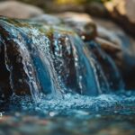 Water flowing over rocks. Olympian Water Testing logo in the corner.
