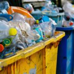 Overflowing recycling bins with plastic waste. Microplastics in drinking water solutions.