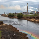 PFAS/PFOS in the Environment: River with industrial pollution. Focus on PFAS sources, impacts, and solutions. Water contamination.