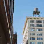 Rooftop water tower design on modern buildings. Aesthetic considerations for urban water storage. Cityscape view.