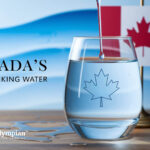 Is Canada tap water safe? Glass of water with maple leaf and Canadian flag. Safe drinking water in Canada.