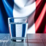 Is tap water in France safe? Glass of water with the French flag and Eiffel Tower in the background.