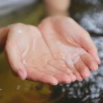 Cupped hands holding clean well water. Landlords in NJ must ensure tenant access to safe drinking water through regular water testing.