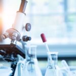 Microscope and lab beakers for well water testing. Lab-based regulatory water analysis.