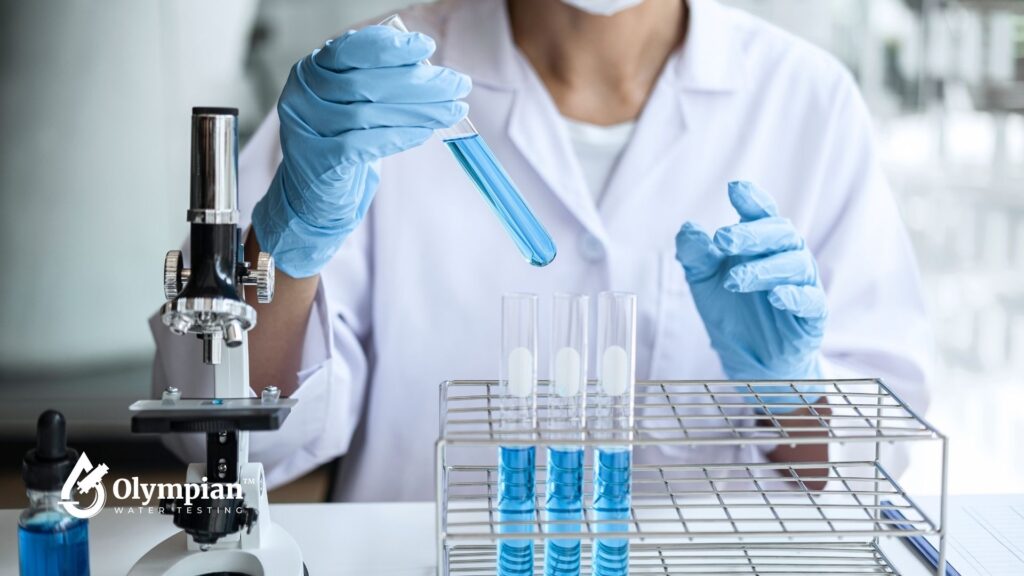 Well water test. Scientist analyzing water sample in lab with microscope. Lab analysis of water quality.