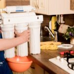 Installing a whole house water filter for well water. Filtration system in kitchen.