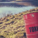 Toxic waste barrel near water. Early water contamination, Flint water crisis.