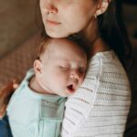 Mother holding sleeping baby. Well water testing is important for infants.