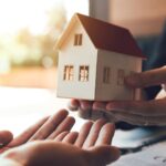 Somerset County real estate: Hands exchanging a model house. Consider well water testing before buying a property.