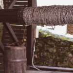 Old wooden well with bucket and chain. Cloudy well water may indicate water quality issues needing testing.